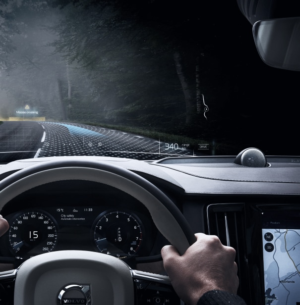 From a driver seat perspective. A person driving at night on a road with simulated 3D rendered dots and road signs.